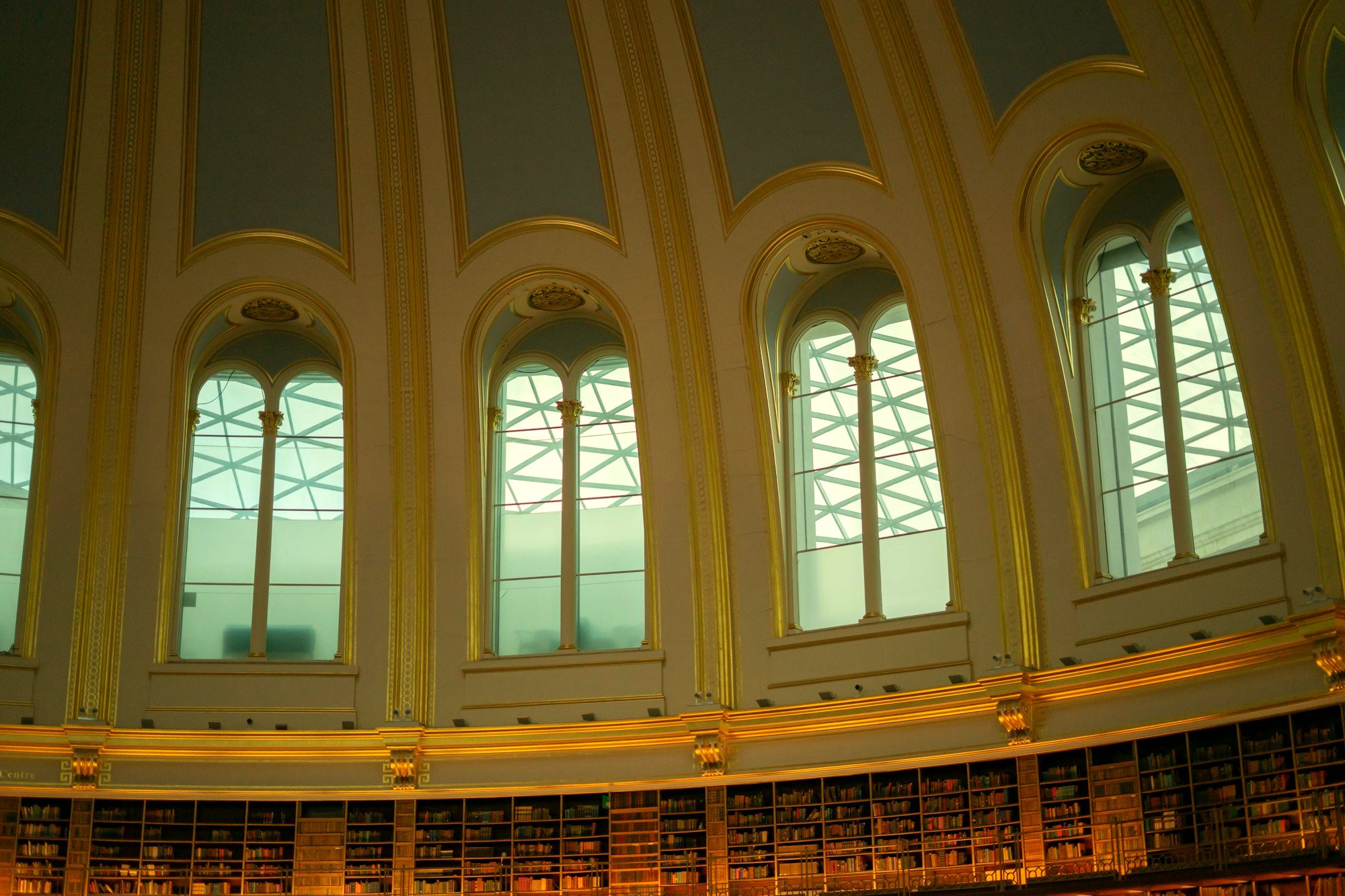 A grand, warm reading room lined with books